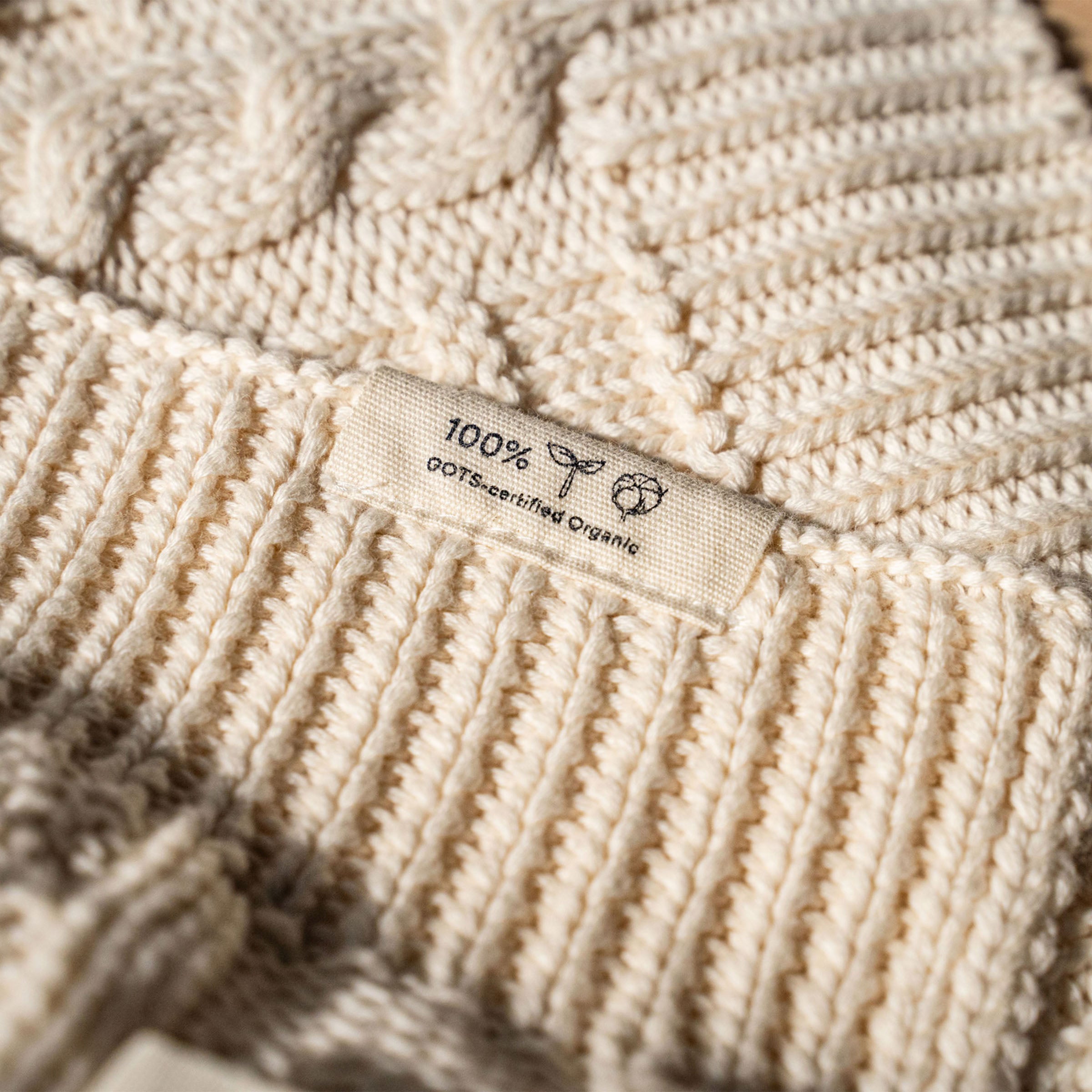 organic-cotton-cable-knit-throw-detail-in-ivory-colour-with-100%-organic-cotton-tag-by-sojao