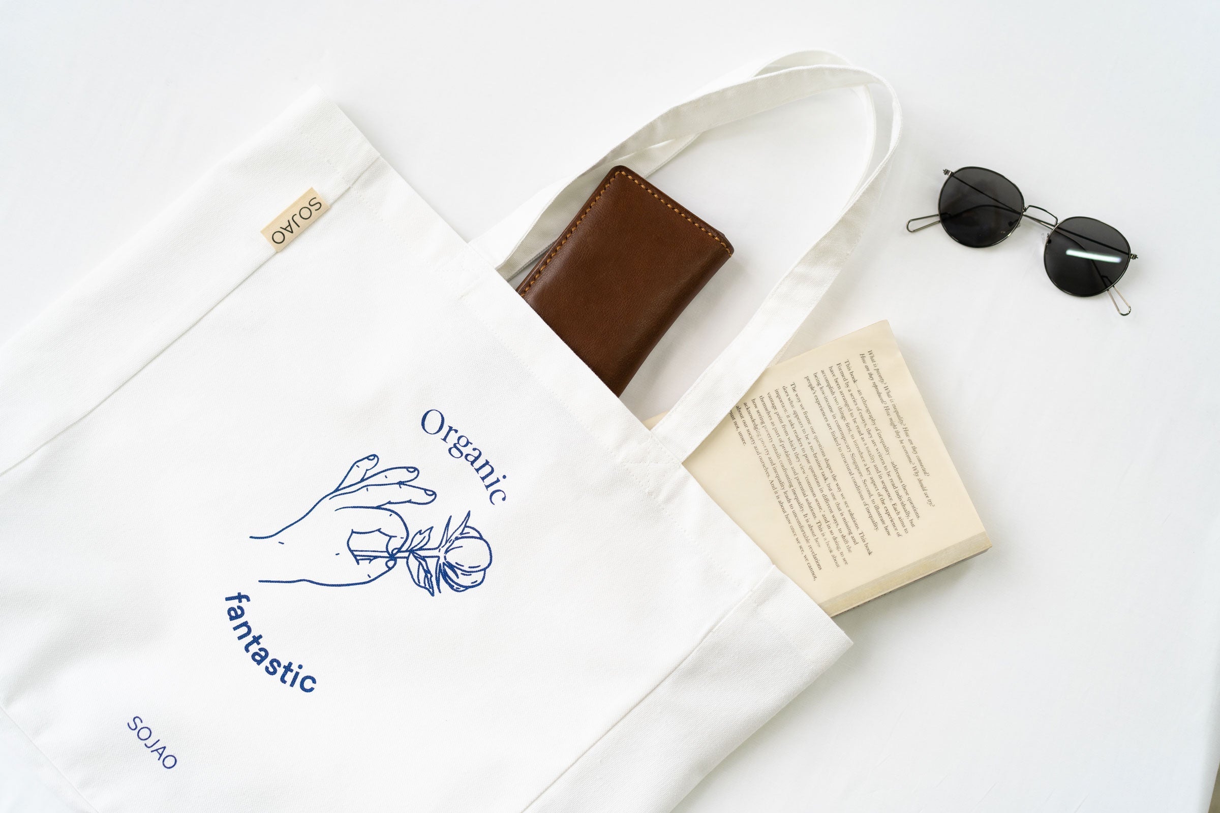 organic-cotton-tote-bag-in-white-colour-with-book-and-sunglasses-by-sojao