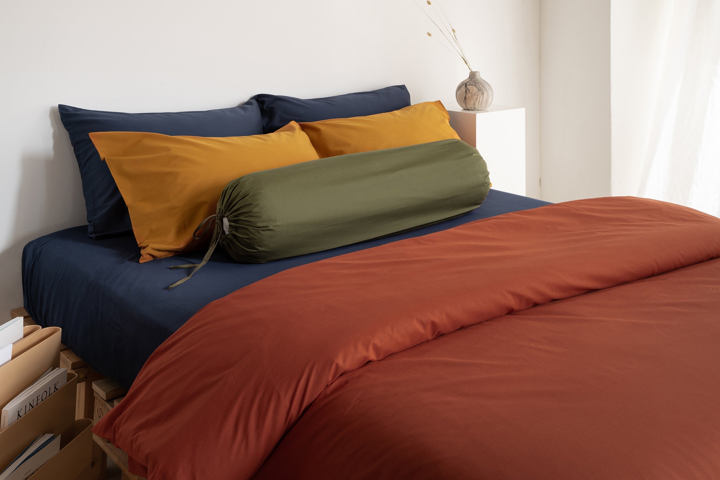 organic-cotton-crisp-bolster-case-in-olive-colour-with-classic-navy-sheet-set-crisp-mustard-pillow-case-pair-and-crisp-clay-duvet-cover-by-sojao